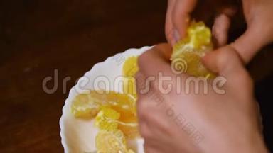双手慢动作剥柑橘类水果.. 健康食品。 女手剥橘子皮。 美味的柑桔片水果